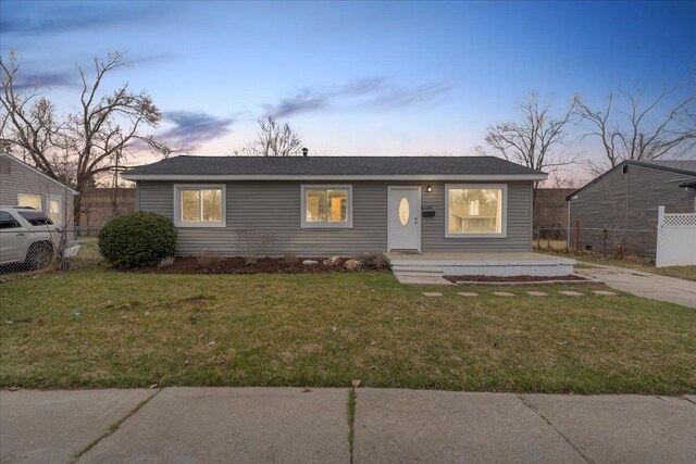 view of front of property with fence and a lawn