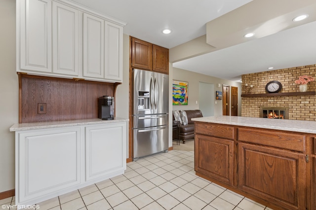 4129 Hailey Dr, Saint Joseph, MI 49085 - kitchen featuring open floor plan, a brick fireplace, stainless steel fridge, recessed lighting, and white cabinets