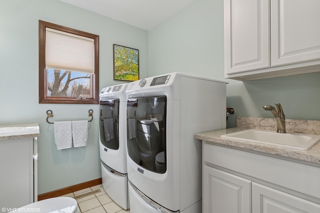 4129 Hailey Dr, Saint Joseph, MI 49085 - washroom featuring light tile patterned floors, baseboards, a sink, cabinet space, and washing machine and dryer