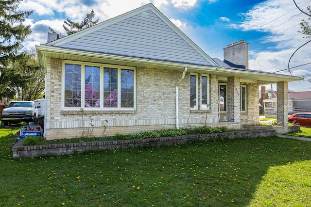 12600 Hayes St, Detroit, MI 48205 - view of front of house featuring a chimney, a front yard, and brick siding