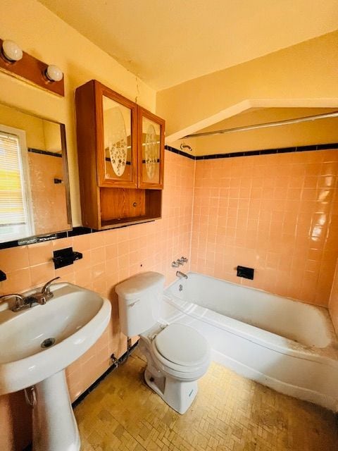 15732 Meyers Rd, Detroit, MI 48227 - full bathroom with bathing tub / shower combination, tasteful backsplash, toilet, and tile walls