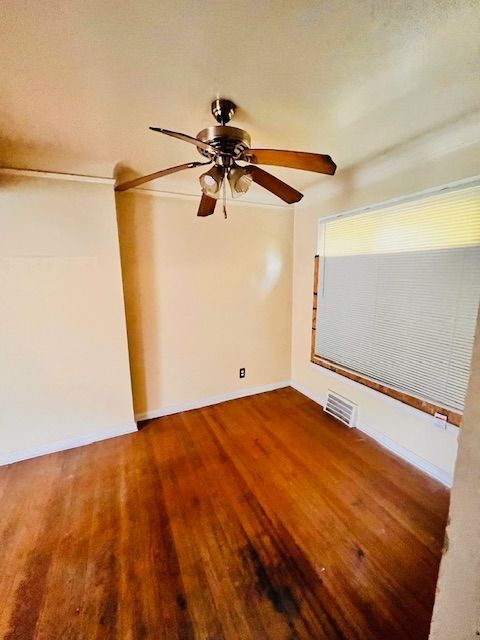 15732 Meyers Rd, Detroit, MI 48227 - spare room featuring baseboards, visible vents, wood finished floors, and ceiling fan