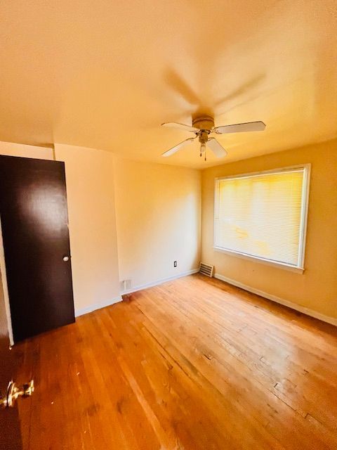 15732 Meyers Rd, Detroit, MI 48227 - unfurnished bedroom featuring baseboards, visible vents, ceiling fan, and wood finished floors