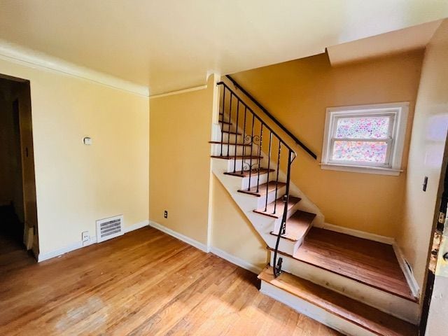15732 Meyers Rd, Detroit, MI 48227 - stairs featuring baseboards, visible vents, crown molding, and wood finished floors