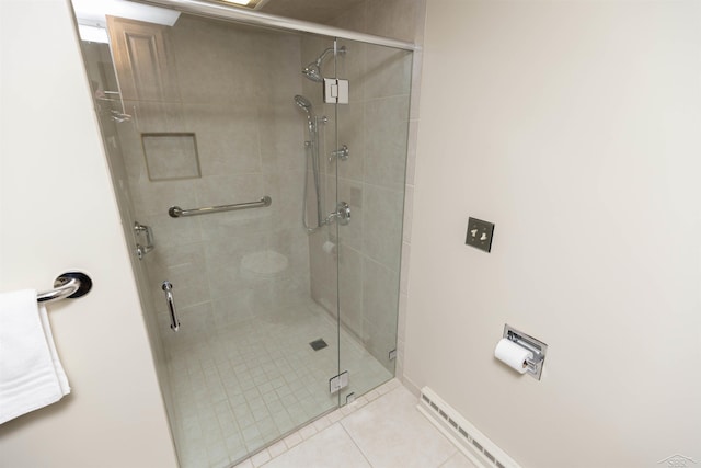 bathroom featuring baseboards, tile patterned flooring, and a shower stall