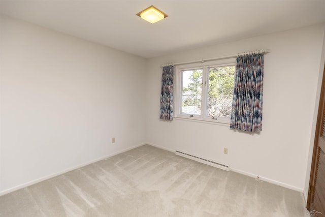 empty room with light colored carpet, a baseboard heating unit, and baseboards
