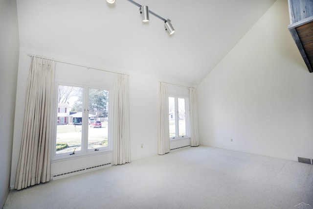 empty room featuring a baseboard radiator, carpet floors, high vaulted ceiling, and visible vents