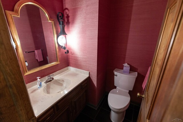 half bathroom featuring toilet, tile patterned flooring, and vanity