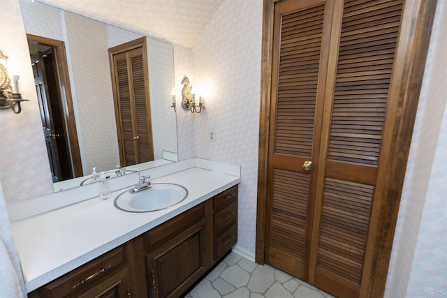 bathroom featuring wallpapered walls, a closet, and vanity