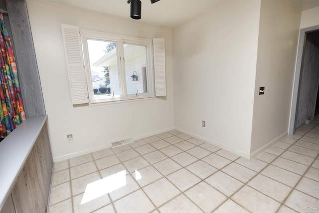 spare room featuring light tile patterned flooring, baseboards, and visible vents