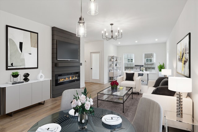 living room with light wood-style flooring, a notable chandelier, a fireplace, and recessed lighting