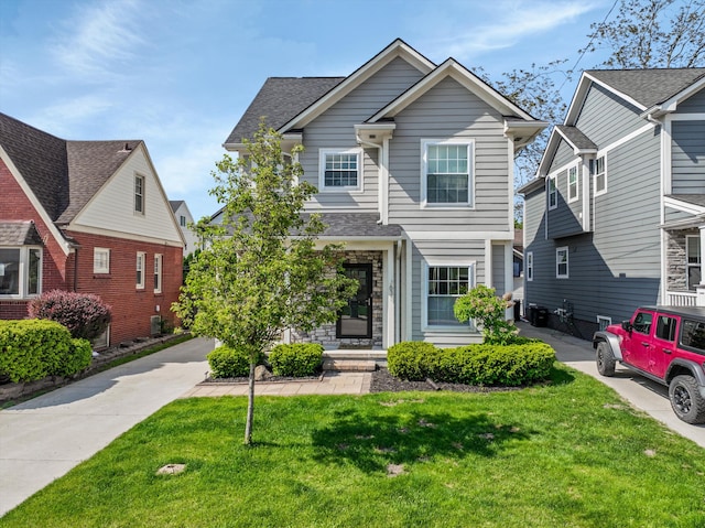 view of front of house with a front lawn, cooling unit, and a shingled roof