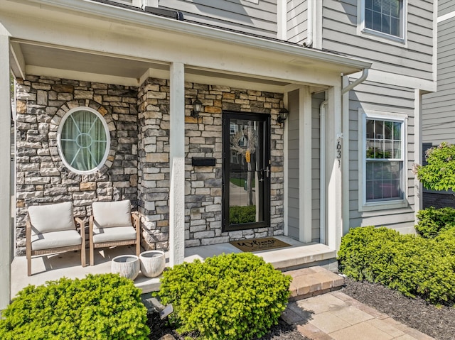 entrance to property featuring stone siding and a porch