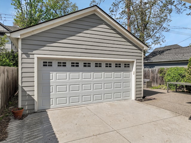 detached garage featuring fence