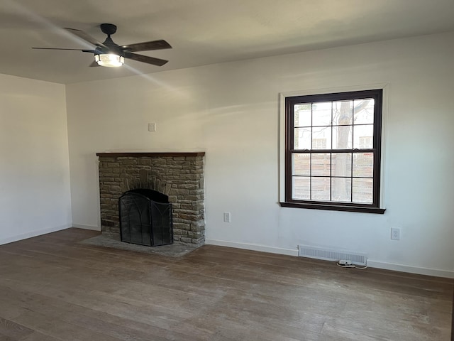 345 S Cochran Ave, Charlotte, MI 48813 - unfurnished living room featuring a fireplace, a ceiling fan, wood finished floors, and visible vents