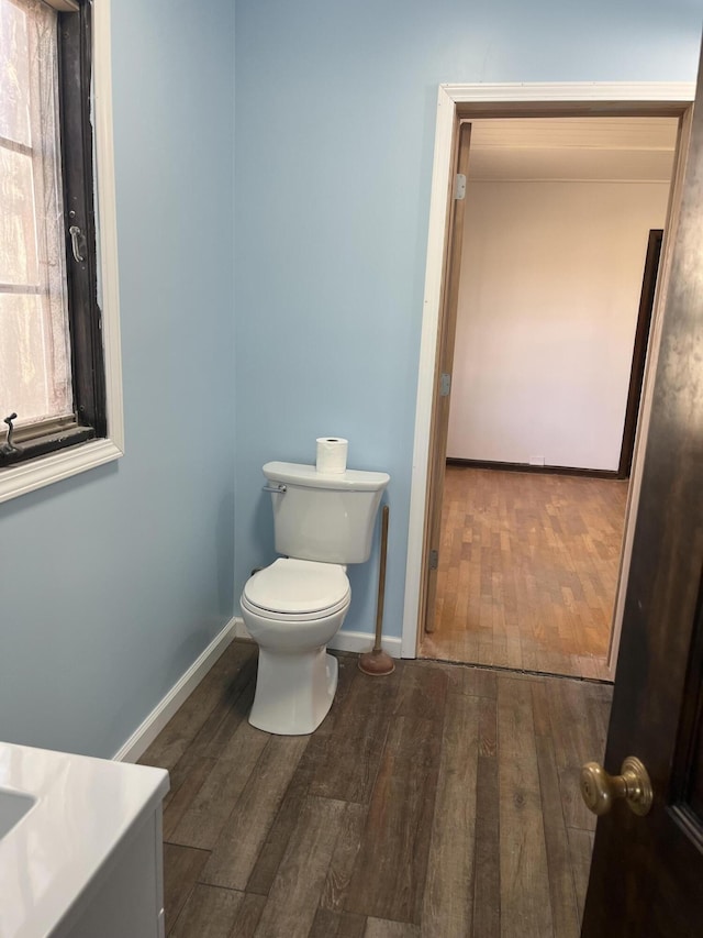 345 S Cochran Ave, Charlotte, MI 48813 - bathroom featuring baseboards, toilet, and wood finished floors