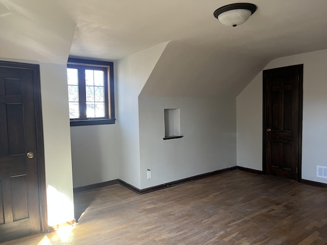 345 S Cochran Ave, Charlotte, MI 48813 - additional living space with baseboards, vaulted ceiling, wood finished floors, and visible vents