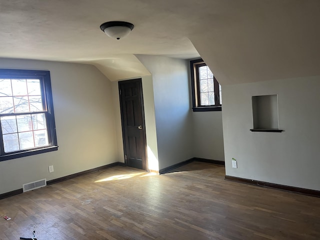 345 S Cochran Ave, Charlotte, MI 48813 - bonus room with visible vents, baseboards, wood finished floors, and vaulted ceiling