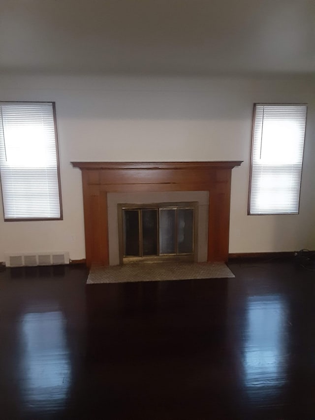 17561 Greenview Ave, Detroit, MI 48219 - unfurnished living room featuring baseboards, visible vents, wood finished floors, and a glass covered fireplace