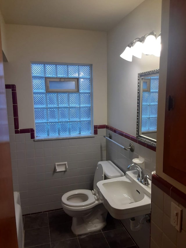 17561 Greenview Ave, Detroit, MI 48219 - full bath with a wainscoted wall, tile patterned floors, toilet, a tub to relax in, and a sink