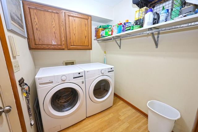 1381 Silverbrook Ln, Saint Joseph, MI 49085 - laundry area featuring washing machine and dryer, light wood-type flooring, cabinet space, and baseboards