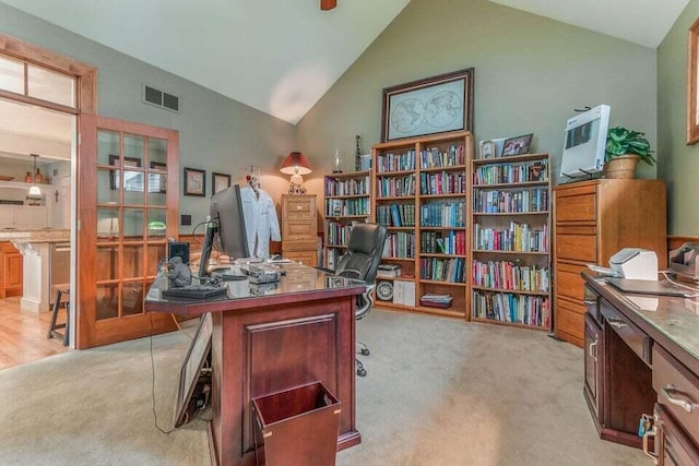 home office featuring high vaulted ceiling, visible vents, and light carpet