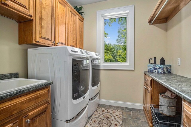 laundry area featuring cabinet space, baseboards, and separate washer and dryer