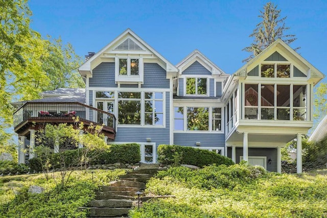 back of property with a sunroom and a wooden deck