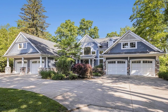 shingle-style home with stone siding and driveway