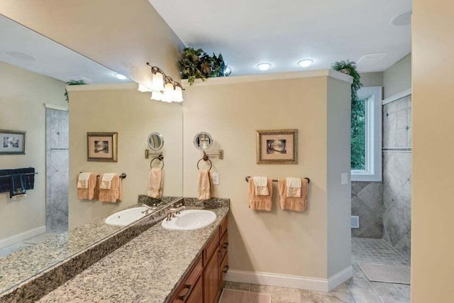 full bathroom featuring vanity, baseboards, and a tile shower
