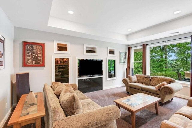 carpeted living room with a tray ceiling, baseboards, visible vents, and recessed lighting