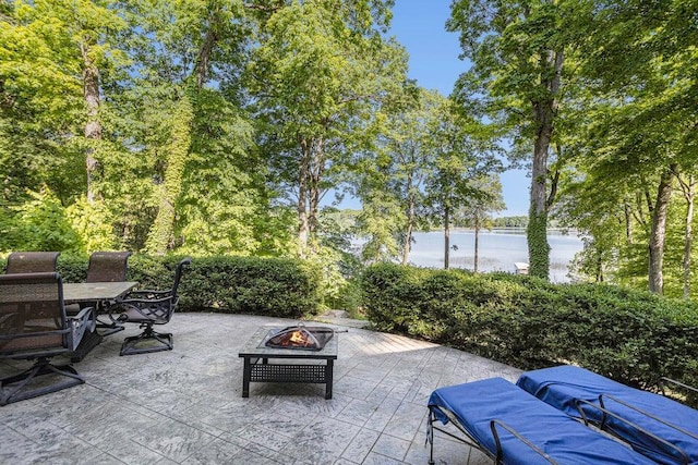 view of patio / terrace featuring a water view, a fire pit, and outdoor dining area