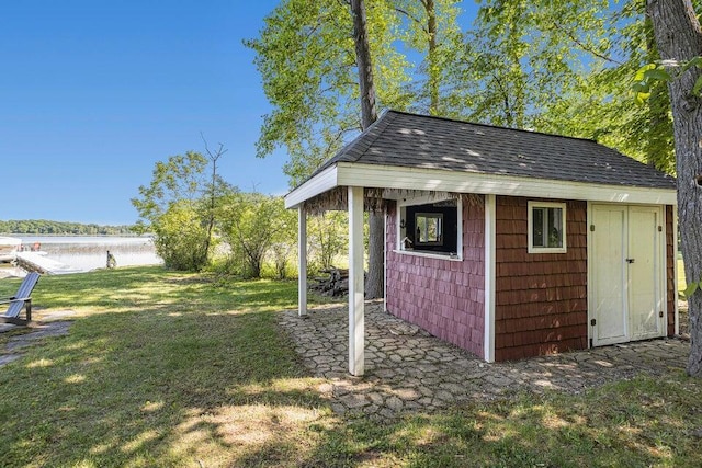 view of outdoor structure with a water view and an outbuilding