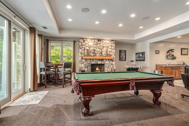 recreation room with a tray ceiling, pool table, a fireplace, light colored carpet, and visible vents