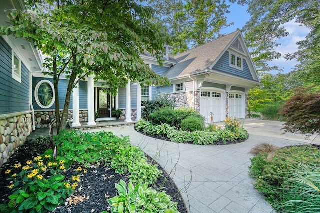 view of front of home featuring stone siding, concrete driveway, and an attached garage