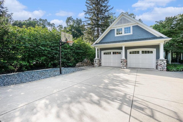 view of side of home featuring stone siding, concrete driveway, and a garage