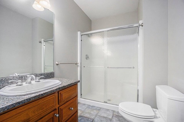 full bath with toilet, vanity, and a shower stall
