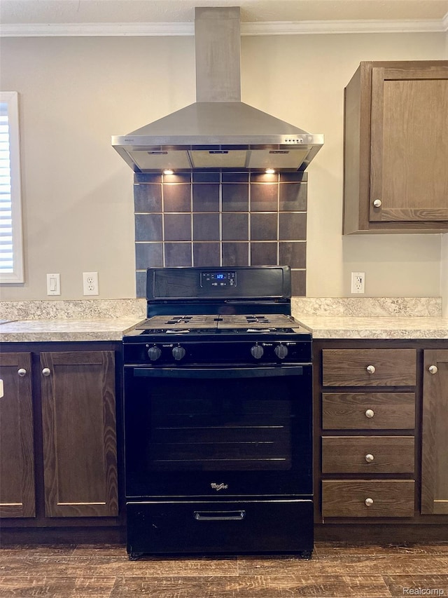 33123 Aspen Ct, New Haven, MI 48048 - kitchen with black gas stove, wall chimney exhaust hood, dark wood-style floors, ornamental molding, and light countertops