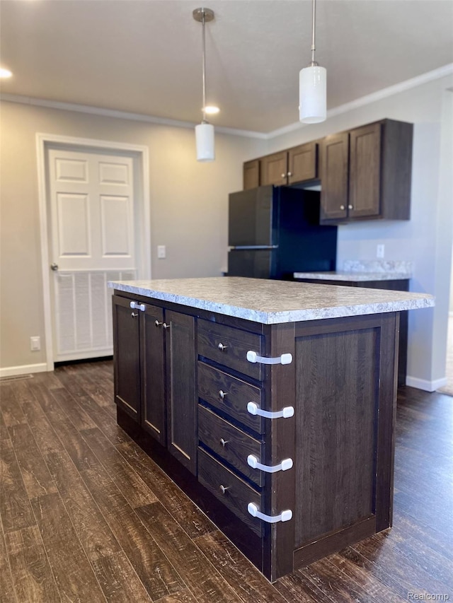 33123 Aspen Ct, New Haven, MI 48048 - kitchen with freestanding refrigerator, dark wood-style floors, light countertops, pendant lighting, and ornamental molding