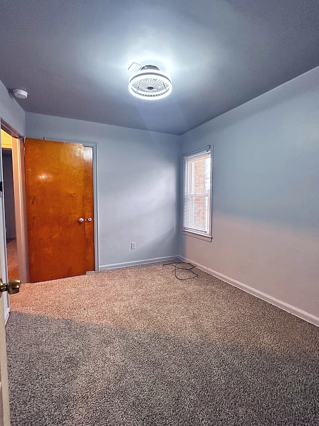 unfurnished room with baseboards and carpet flooring