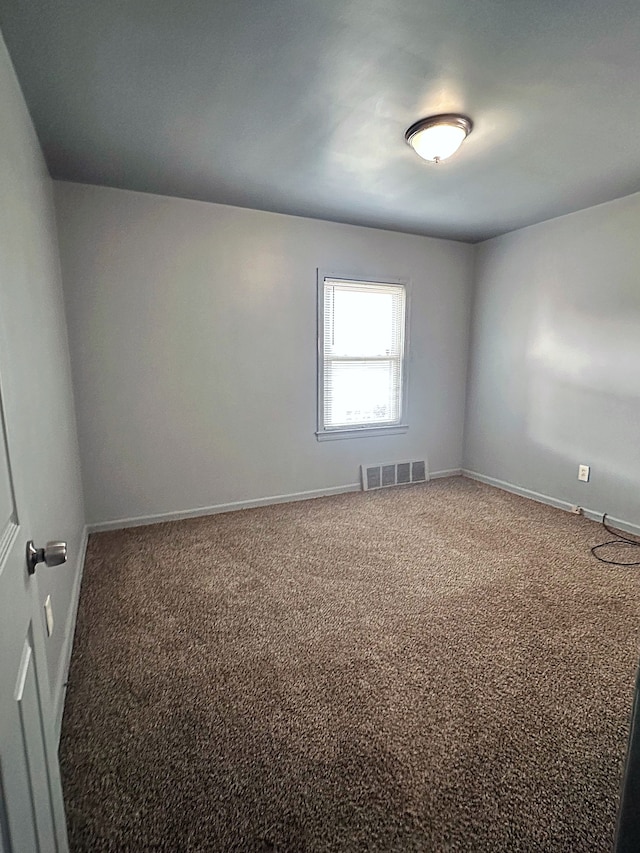 spare room featuring baseboards, visible vents, and carpet flooring