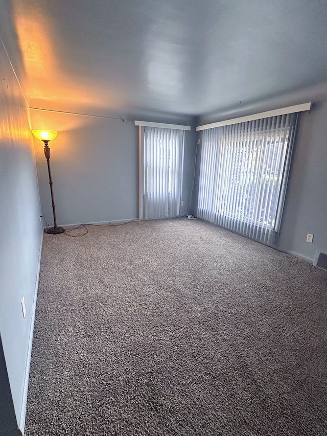 carpeted spare room with plenty of natural light and visible vents