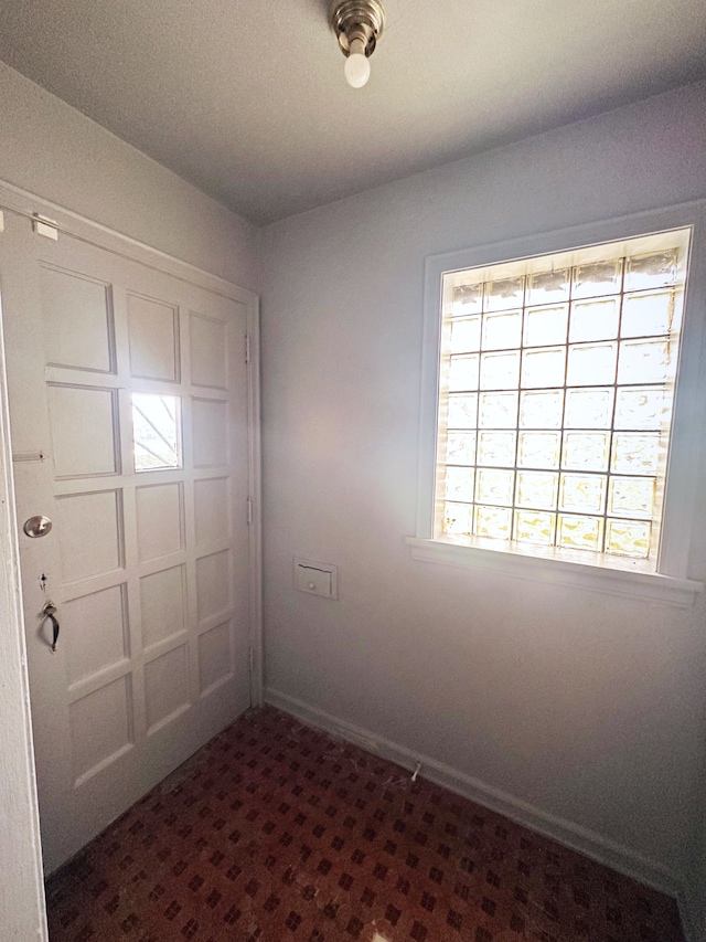 unfurnished room with baseboards