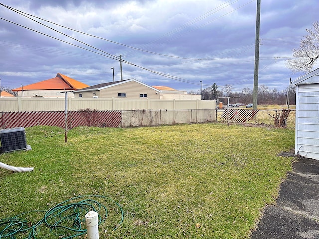 view of yard featuring central air condition unit and fence