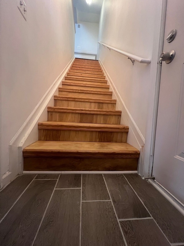 stairs with a baseboard radiator and wood finished floors