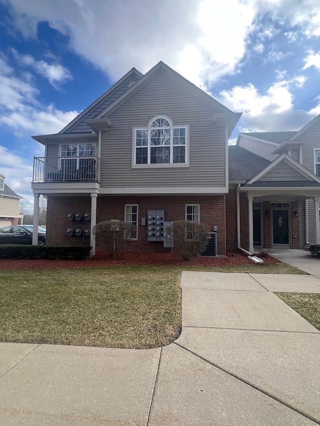 view of front of home with brick siding and a front yard