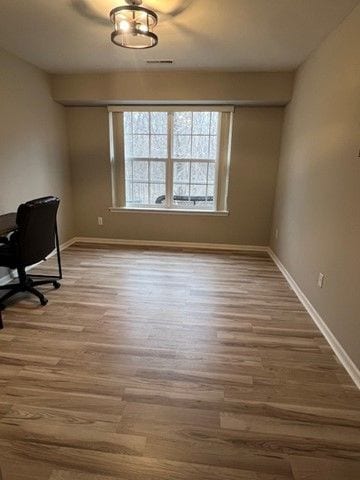 office space with baseboards and wood finished floors
