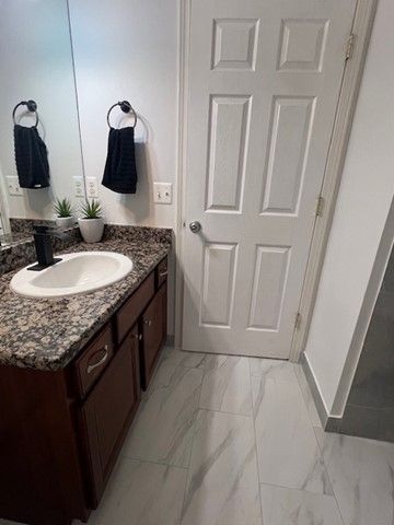 bathroom with marble finish floor and vanity