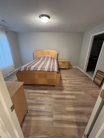 bedroom featuring baseboards and wood finished floors