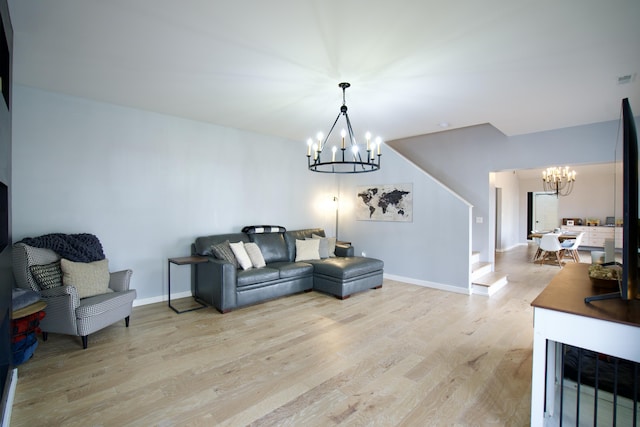 living room featuring baseboards, a chandelier, and light wood-style floors